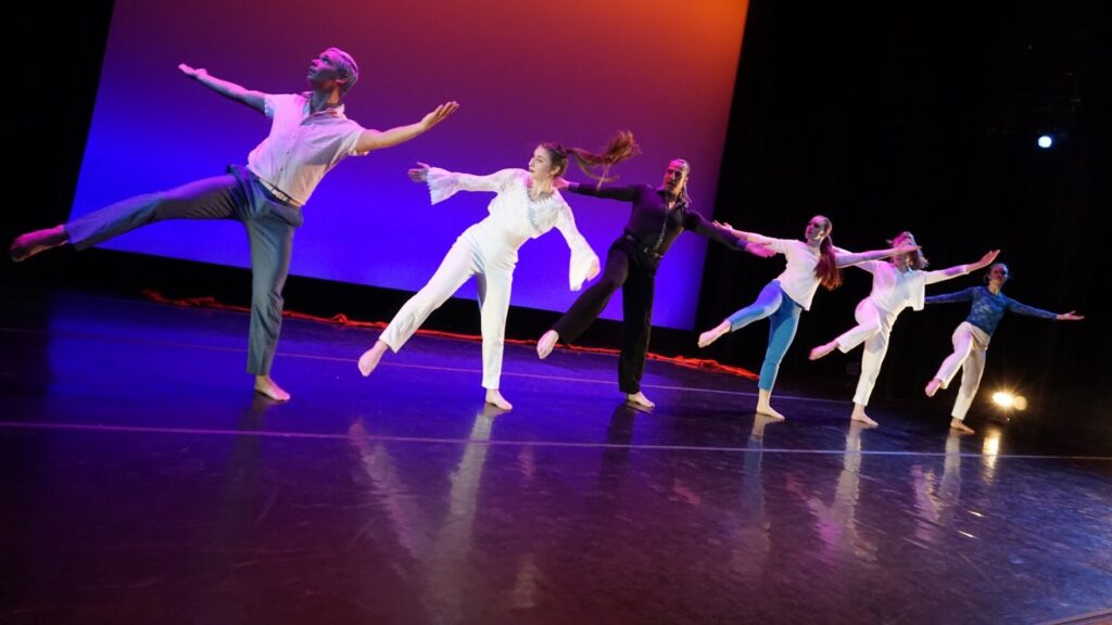 Six dancers are shown on a stage.