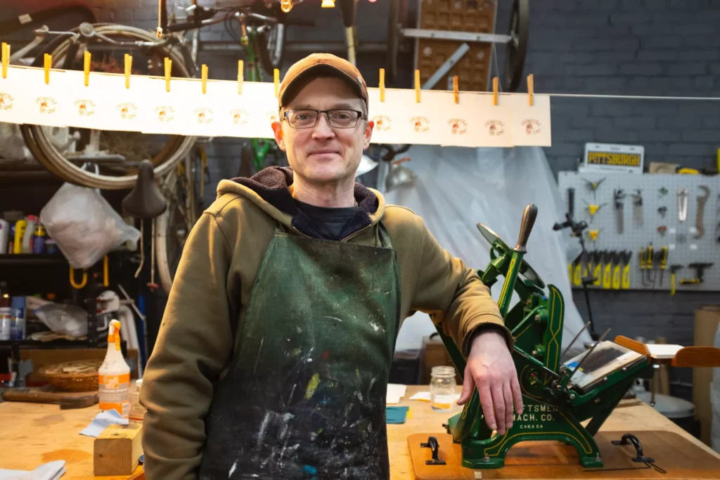 A man poses for a photo in an art studio.