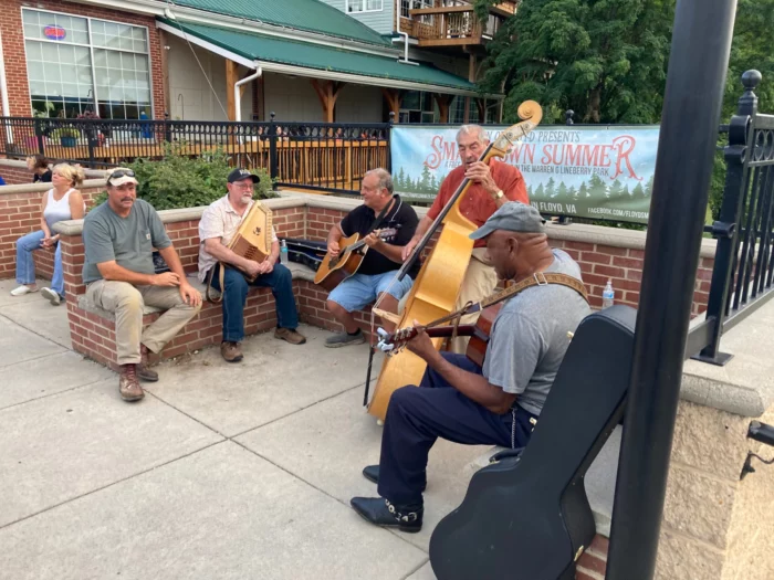 A circle of musicians play on the street at the Friday Night Jamboree in Floyd, Virginia.png