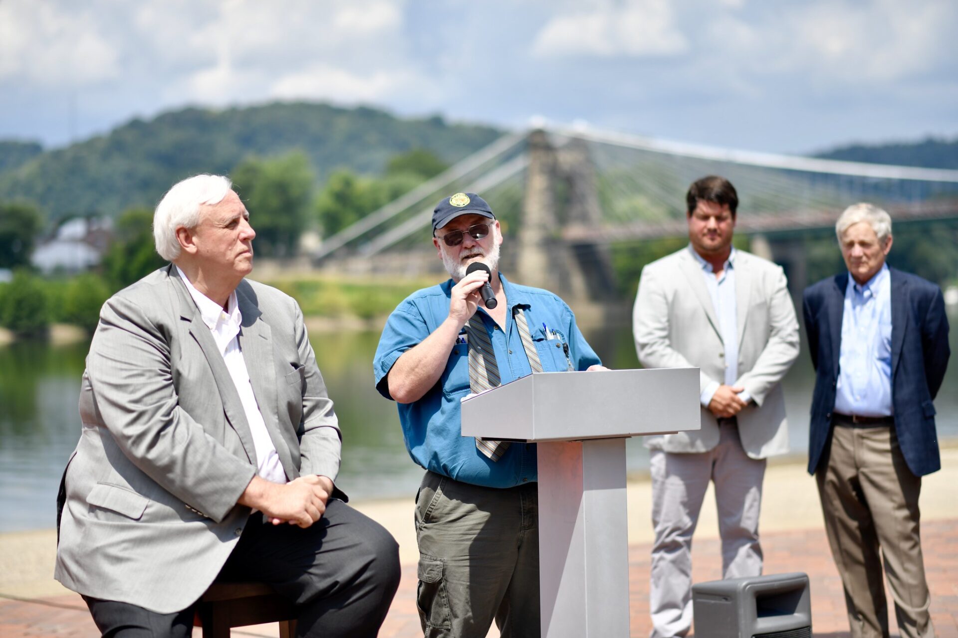 Gov. Jim Justice listens as Division of Highways Secretary Jimmy Wriston talk about a $215 million bridge project in Wheeling in August 2019.