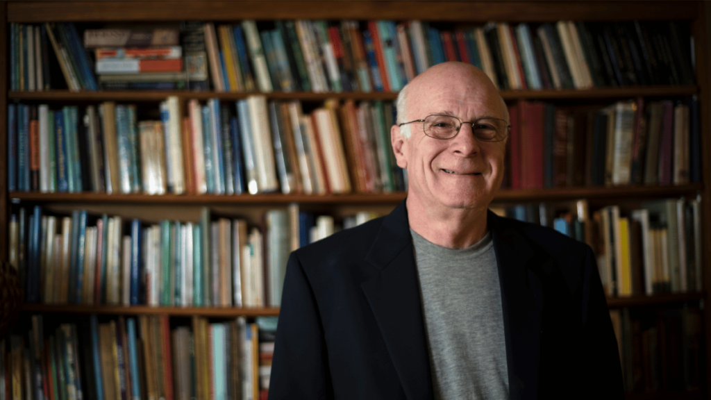 West Virginia Poet Laureate stands smiling in front of a bookshelf.