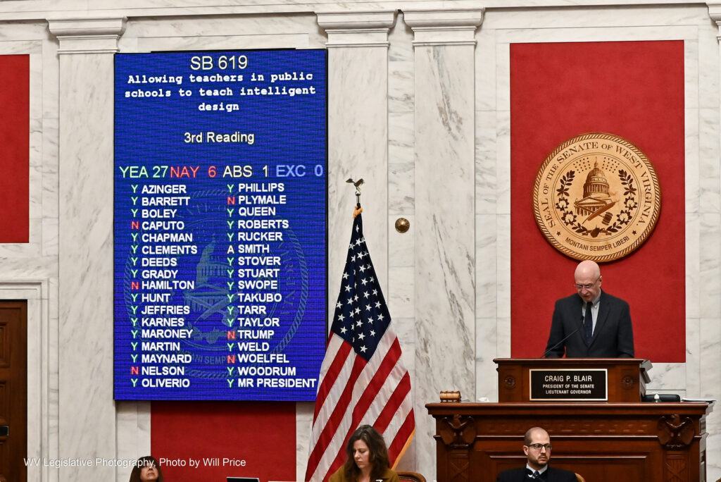 The Senate vote on Senate Bill 619, titled allowing teachers in public schools to teach intelligent design, is displayed next to Senate President Craig Blair as he stands on the Senate dais.