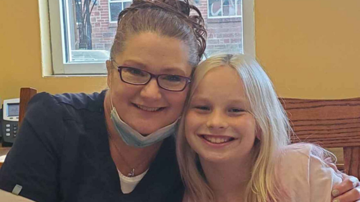 BPJ, the Harrison County student, with medium length blonde hair, and her mother, mask on her chin.