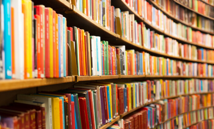 Several books line rows of bookshelves in a library.