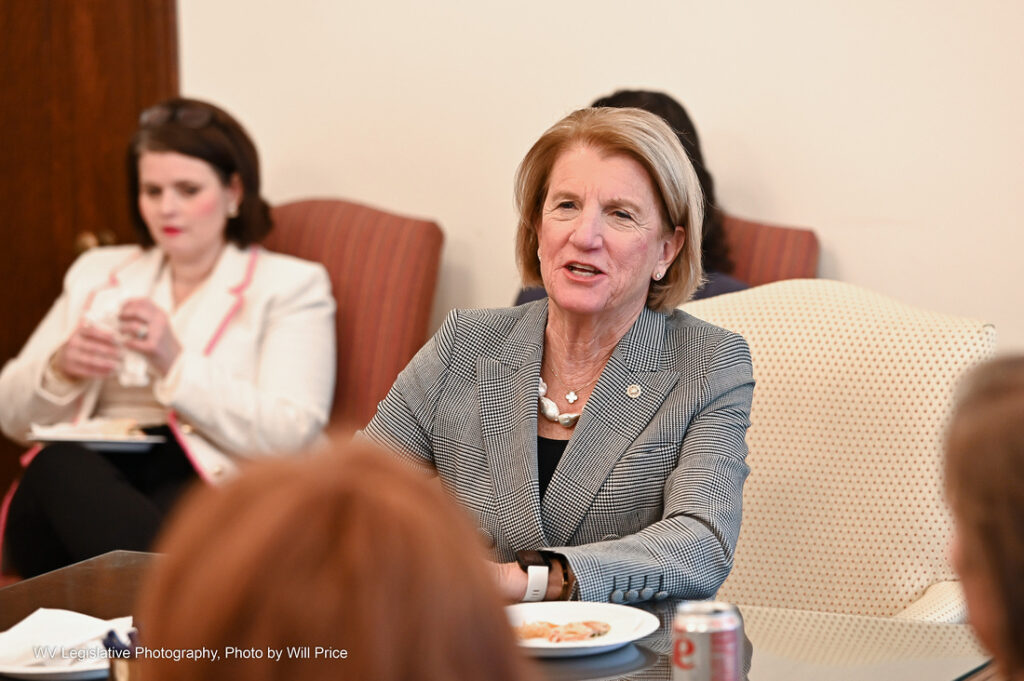 U.S. Sen. Shelley Moore Capito, dressed in a gray blazer, speaks to a group of women in the West Virginia Legislature.