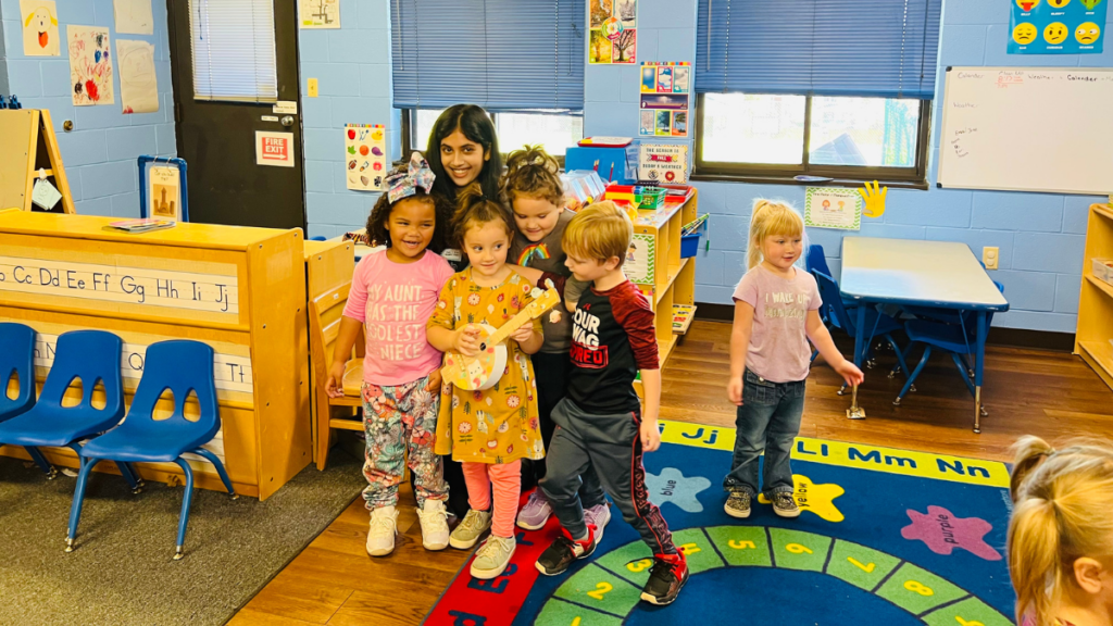 Rania Zuri stands with preschoolers during a reading of her book, “It's Mountain Music to My Ears.”
