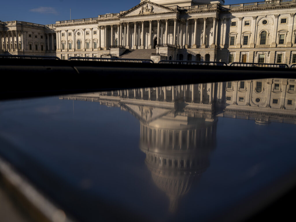 The Dome of the U.S. Capitol Building is visible in a reflection on Capitol Hill in Washington, Jan. 23, 2023