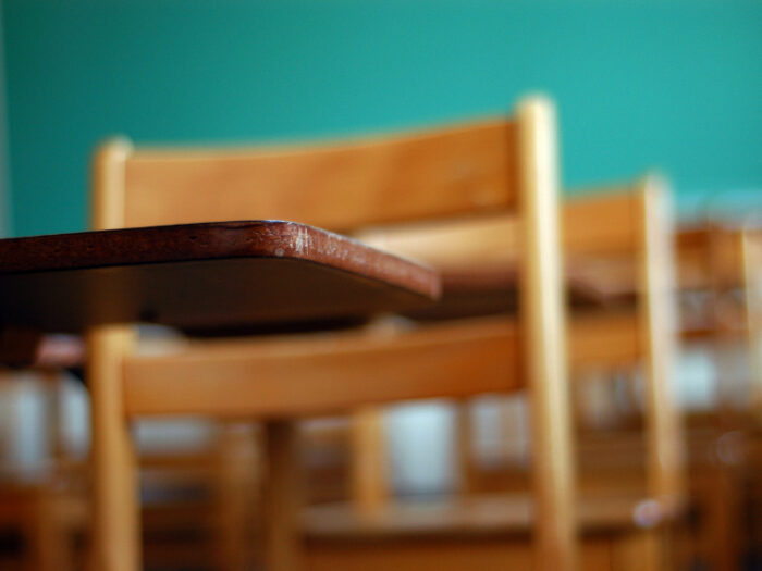 Wooden classroom desks in close up with no students.