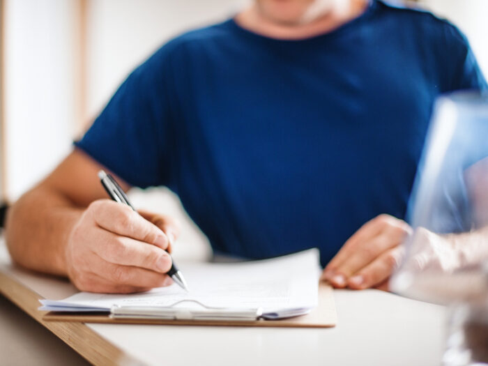 A person fills out paperwork on a clipboard.