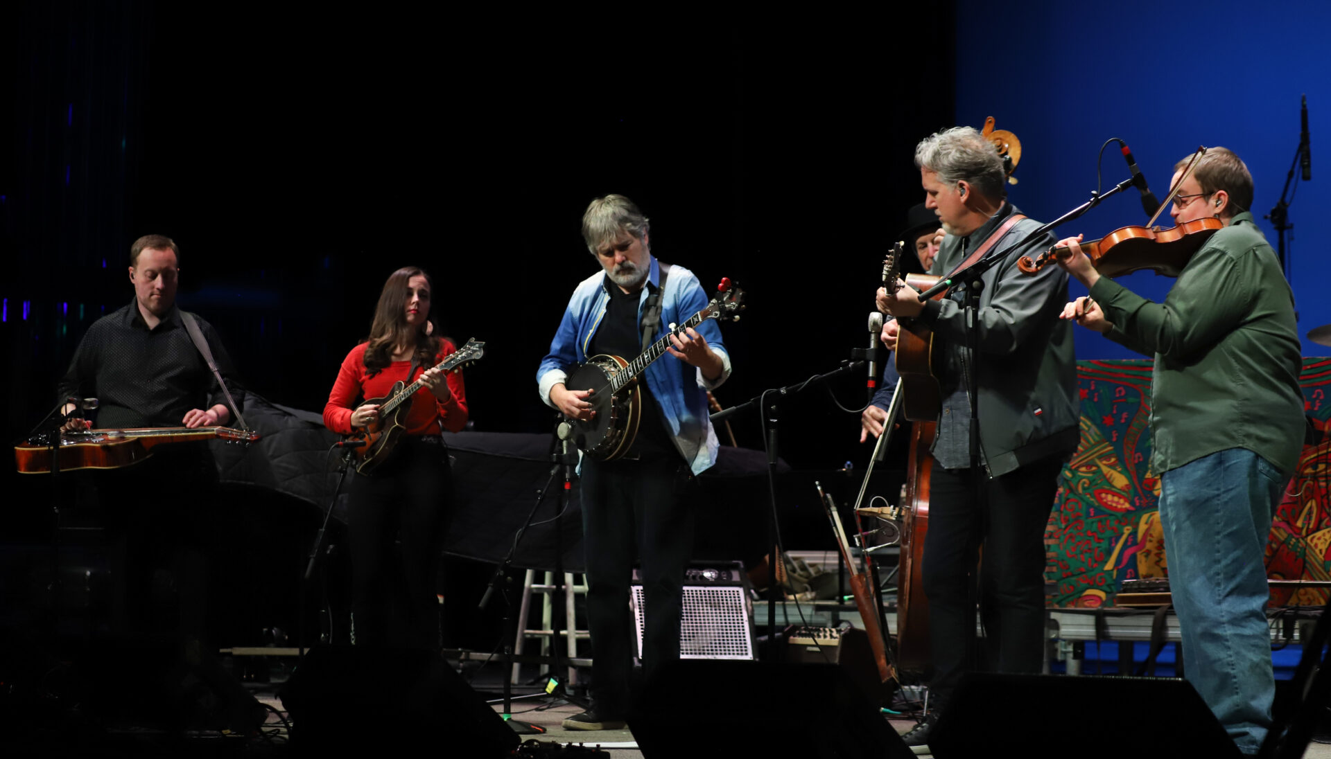 Musicians with bluegrass instruments performing on stage.