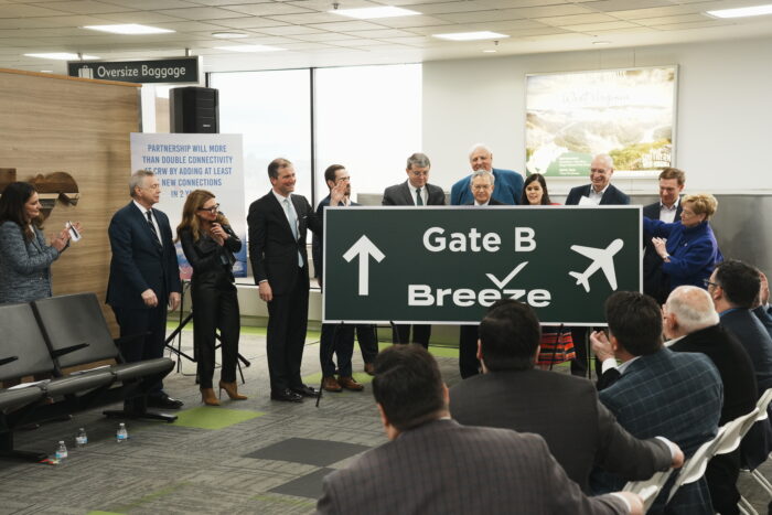 Several people holding airlines sign in airport terminal.