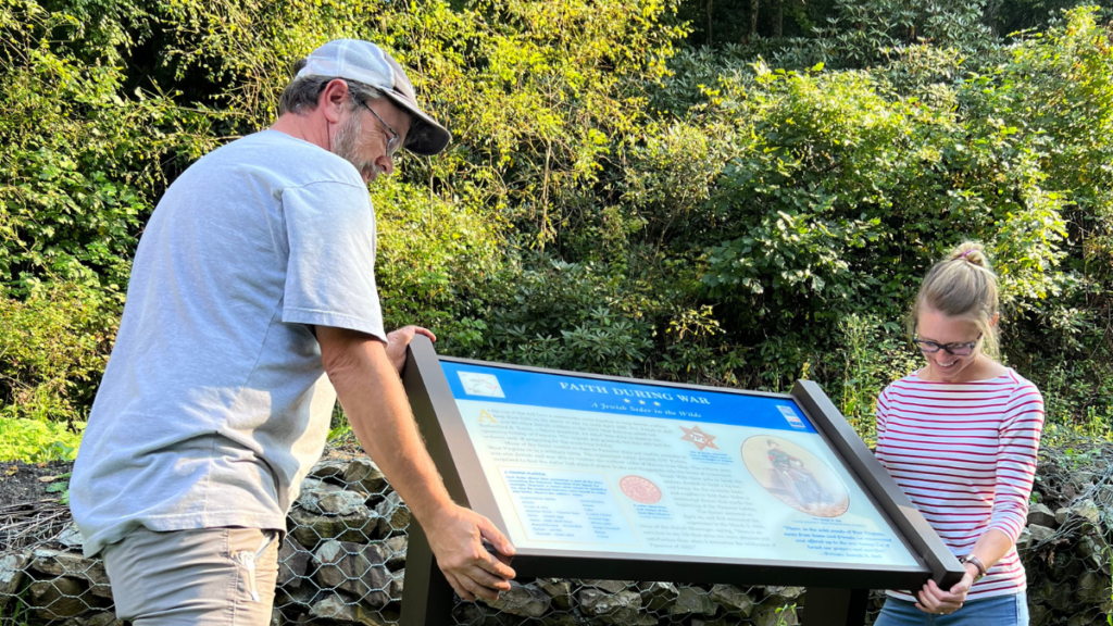 Two people, a man and a woman, install a Civil War historic location sign.