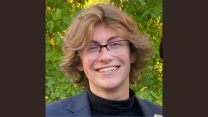 A smiling high school student with glasses. Male.