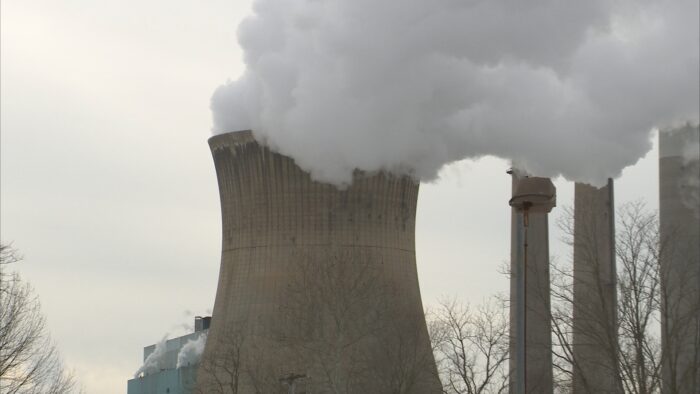 White steam billows from one of the concrete cooling towers at the Pleasants Power Station in Pleasants County.