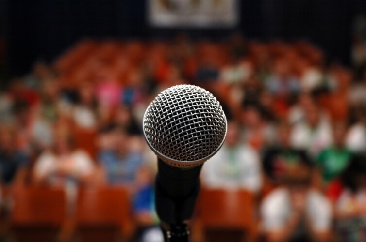 A microphone in front of a crowd in a theater.