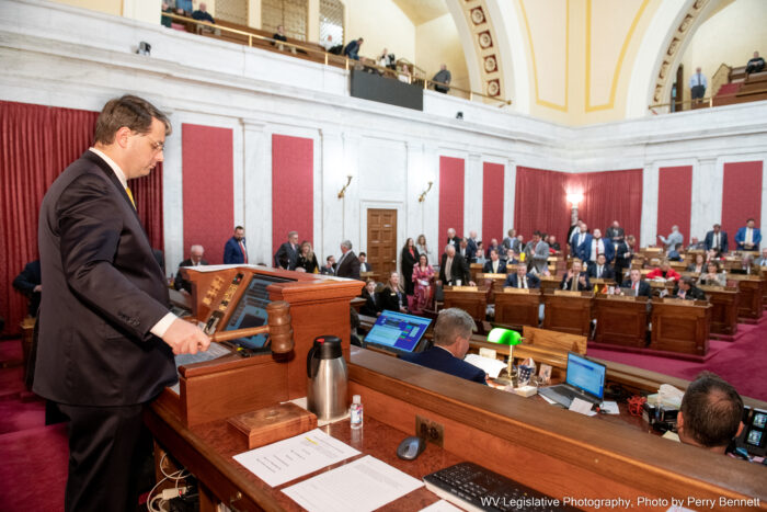 Man with a gavel pounds it on podium to end the legislative session.