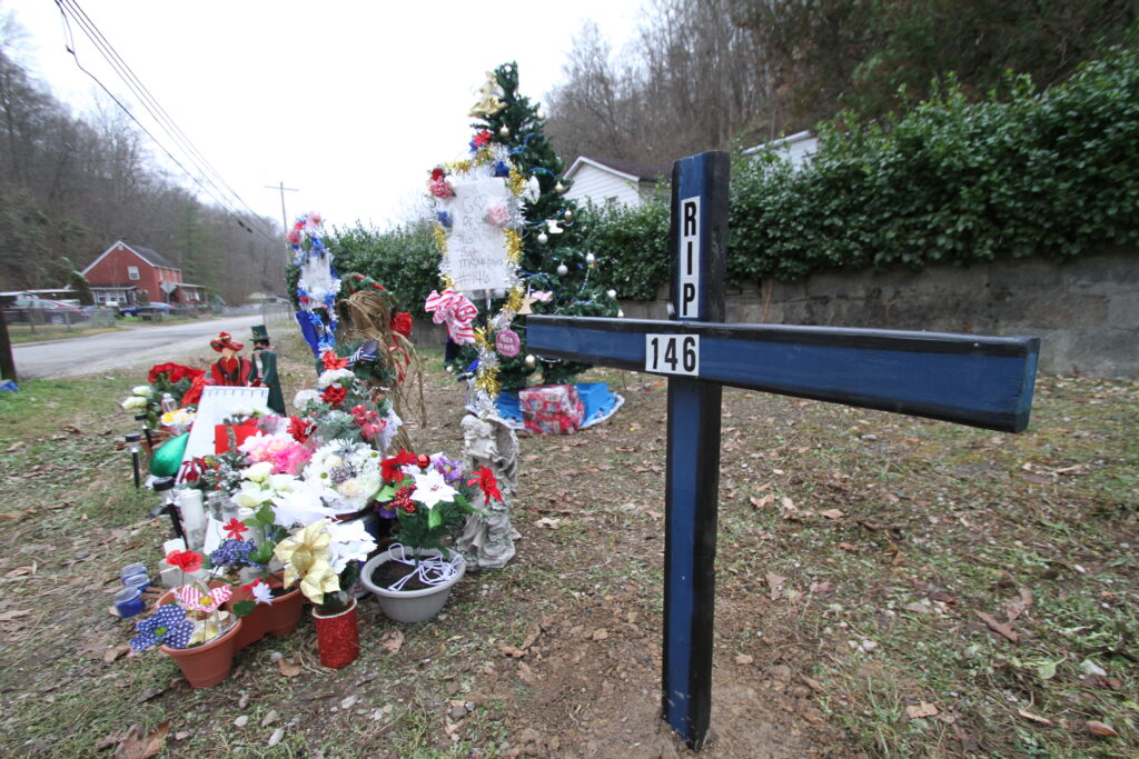 A memorial for Patrol Officer Cassie Johnson is marked with a blue and black cross and flowers.