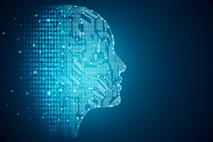 A digital illustration of artificial intelligence. Pictured is the profile shape of a human face made out of computer code against a blue background.