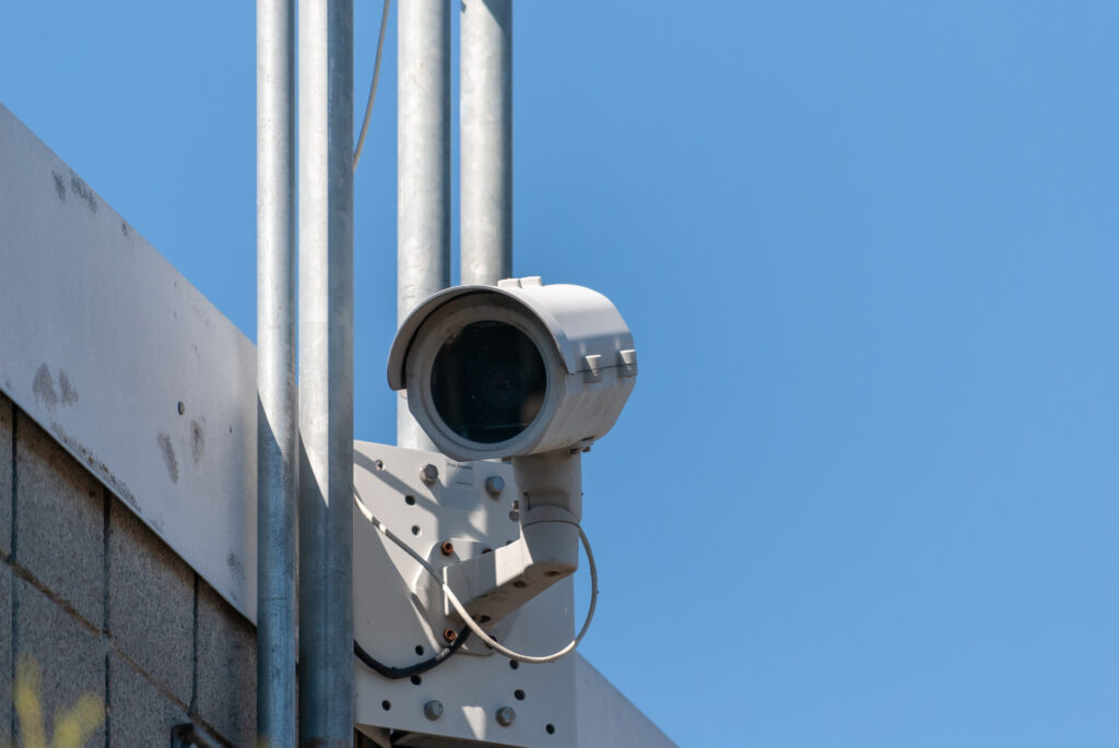 A white security camera on the Mount Vernon river walk is contrasted against the blue sky.