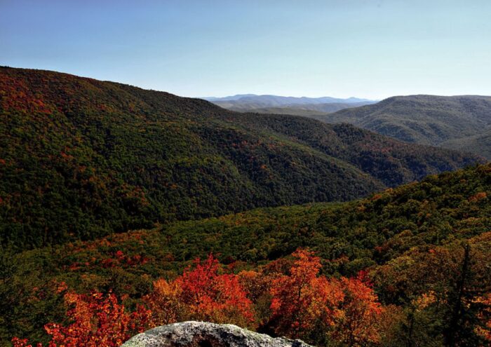 Fall colors cover the rolling hills of West Virgnia under a clear sunny sky.