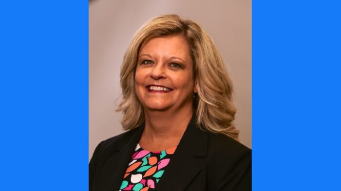 A headshot of Michelle Blatt on a blue background.