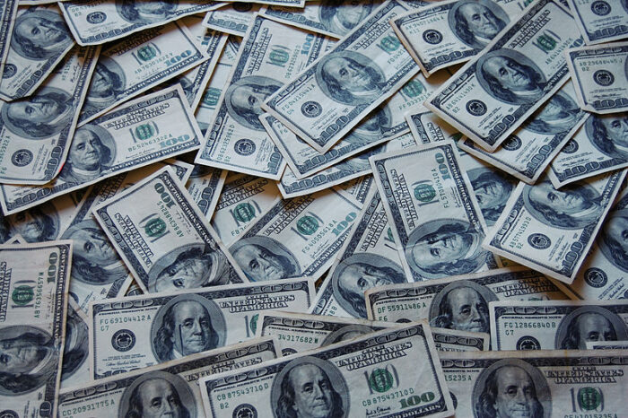 Stacks of $100 bills are seen stacked on top of another.
