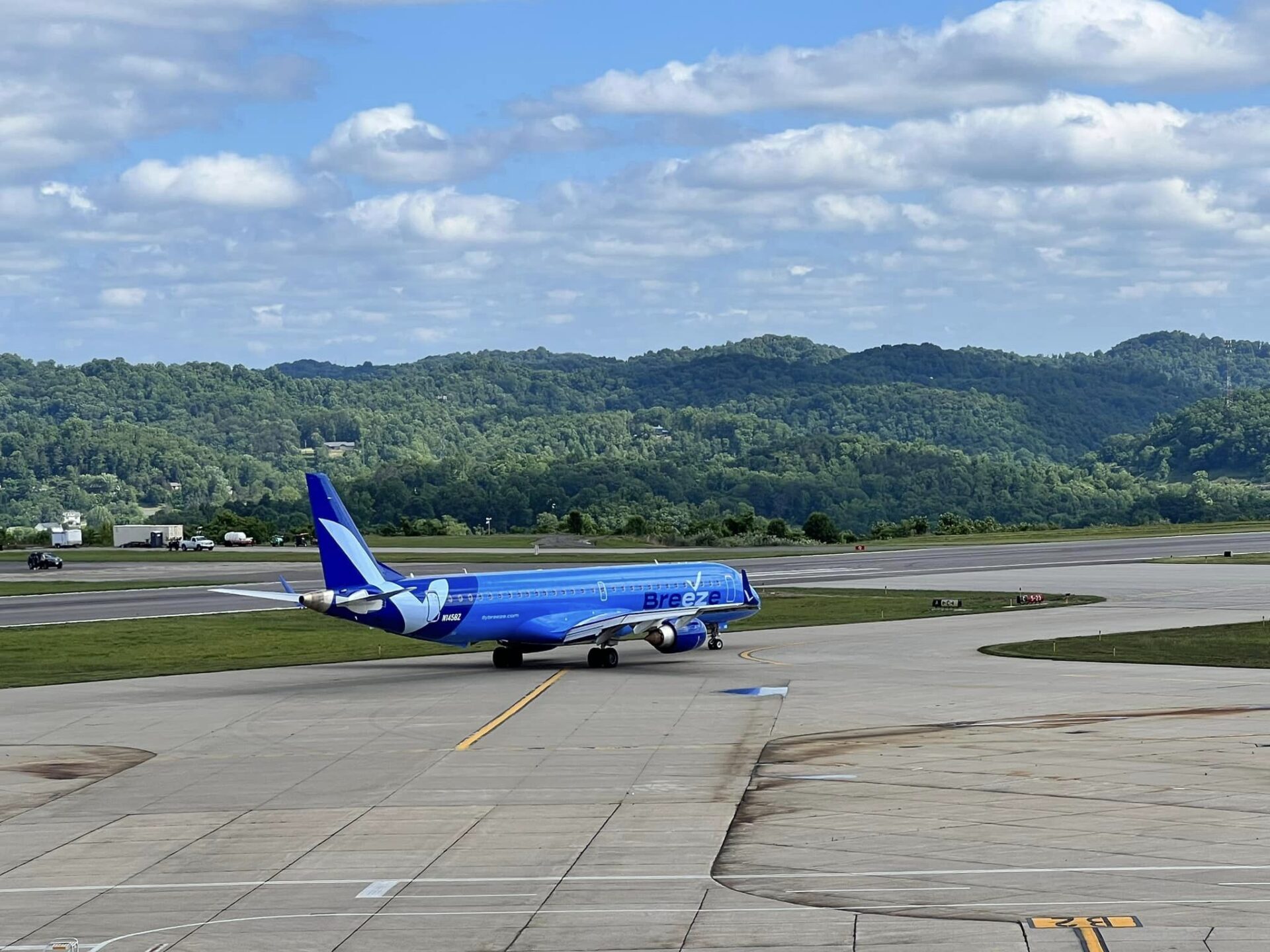 A blue Breeze Airlines jet is seen taxiing on the tarmac at West Virginia International Yeager Airport.