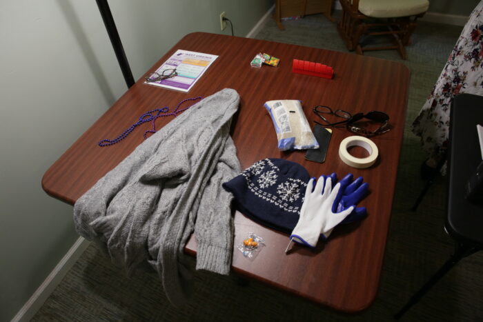 A table with a sweater, hat and gloves. 
