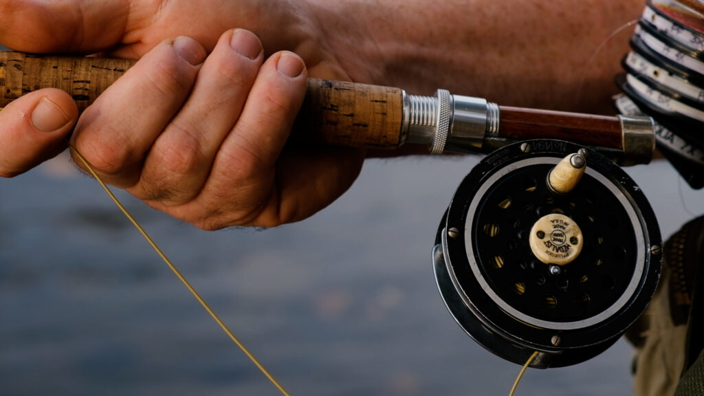 Close up of a man's hand on a fishing rod.