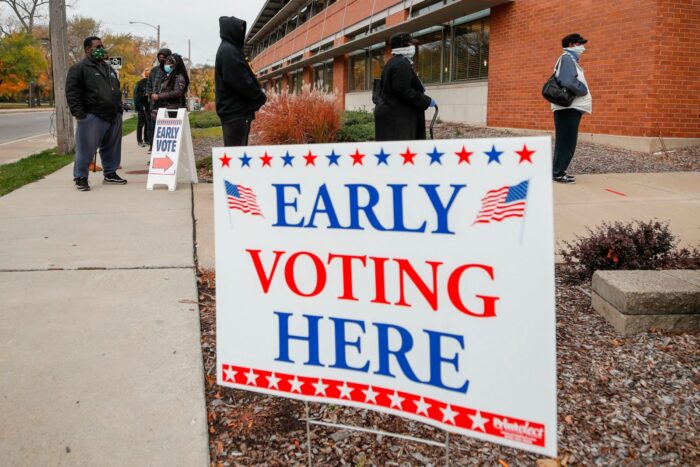 A blue and red sign for early voting posted in front of polling station.