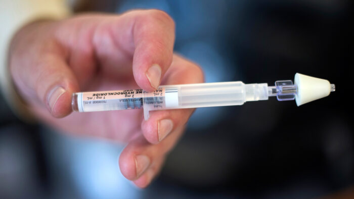 A physician holds a syringe of the opioid overdose reversal drug, Narcan.