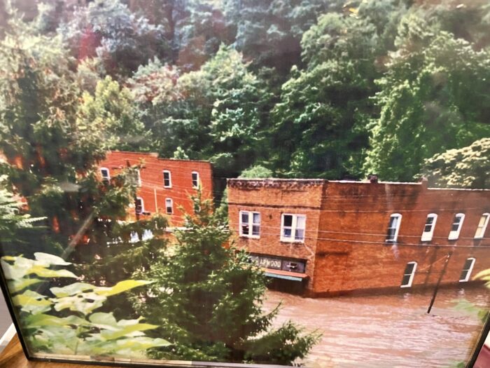 A photo of a flooded brick building surrounded by trees.