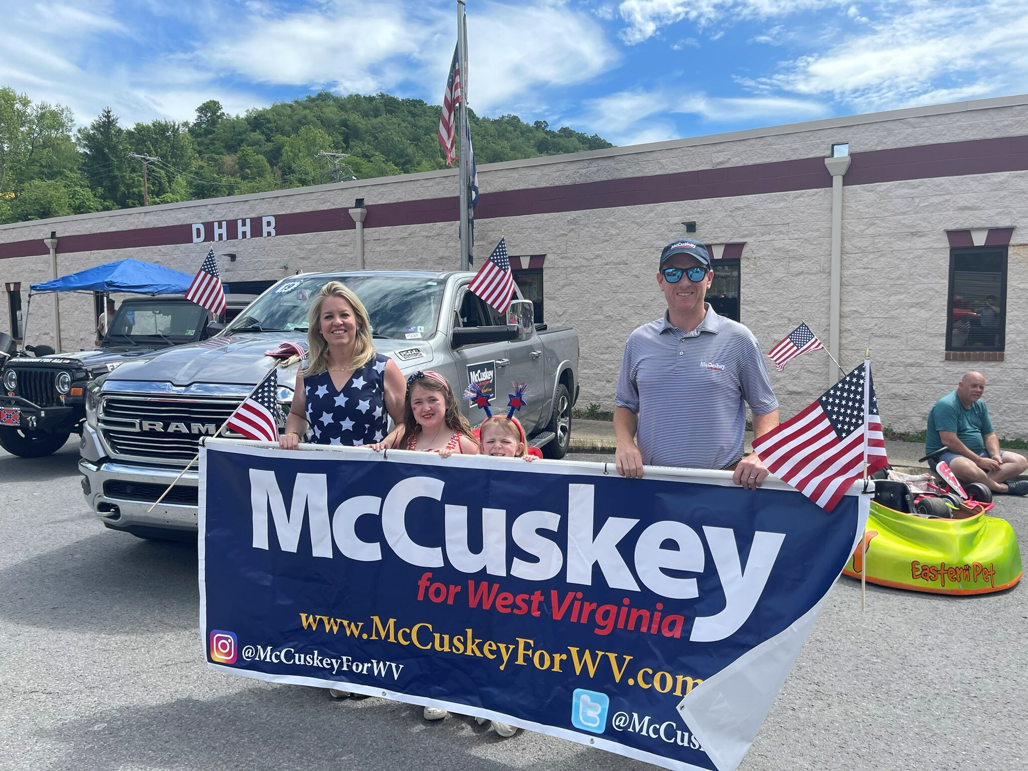 A political candidate standing with his family behind a campaign sign