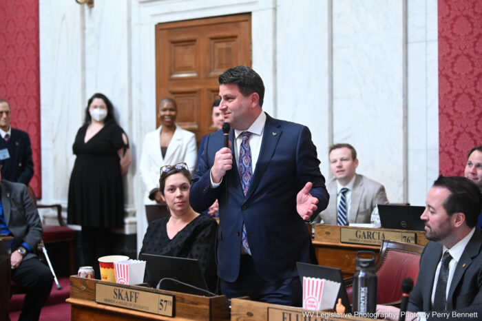 Man in blue suit standing and talking