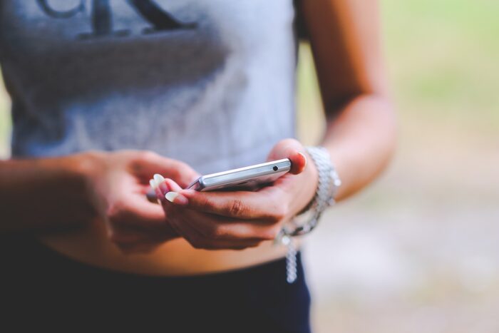 A person is holding a cell phone reading a text message.