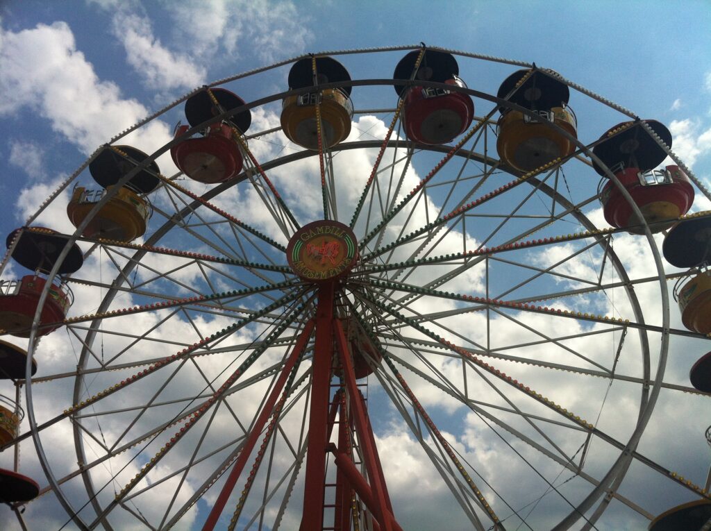 A Ferris wheel is seen against a blue cloudy sky.