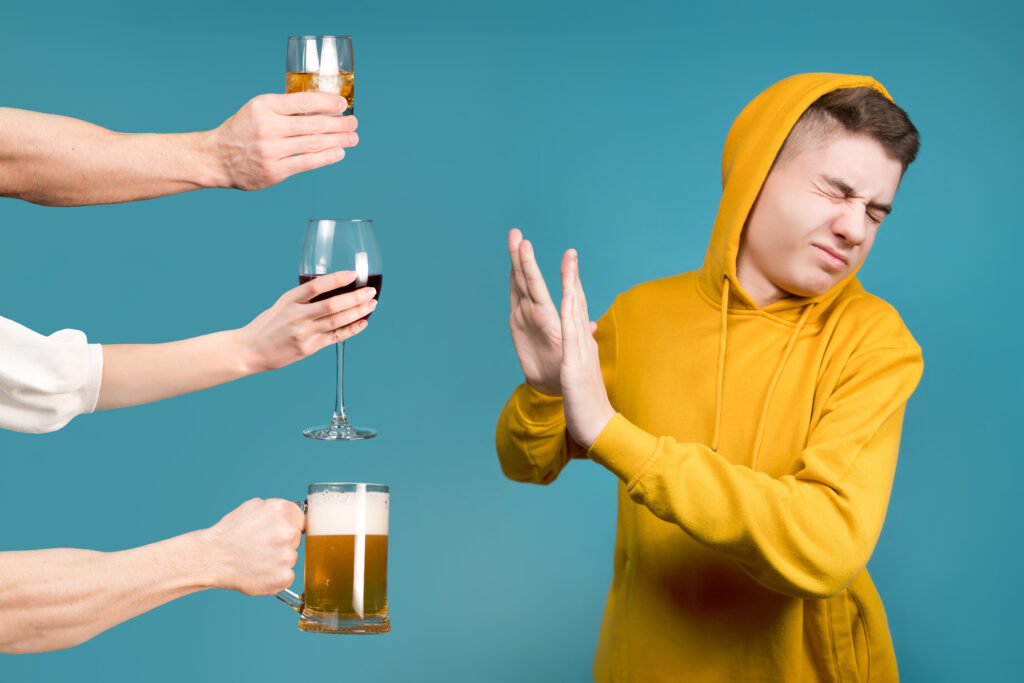 Teenager in a yellow sweatshirt refuses different types of alcohol