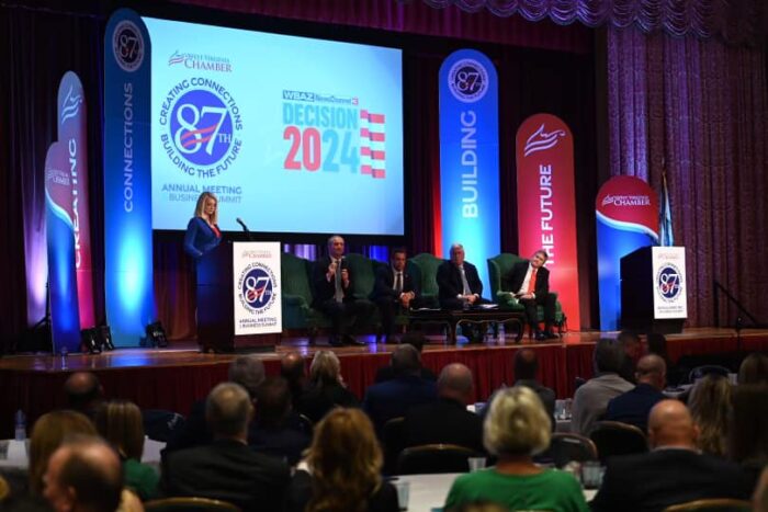 Four men and a woman at a podium on a stage.