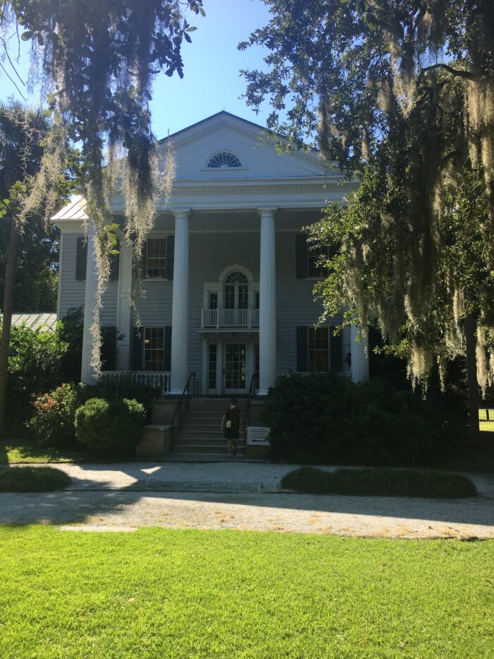 An old plantation home is shown on a sunny day. 