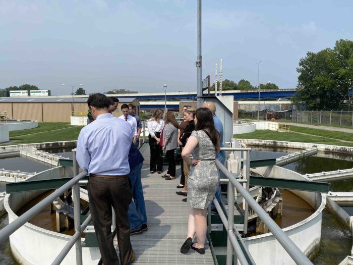 A group of people inspect a water system