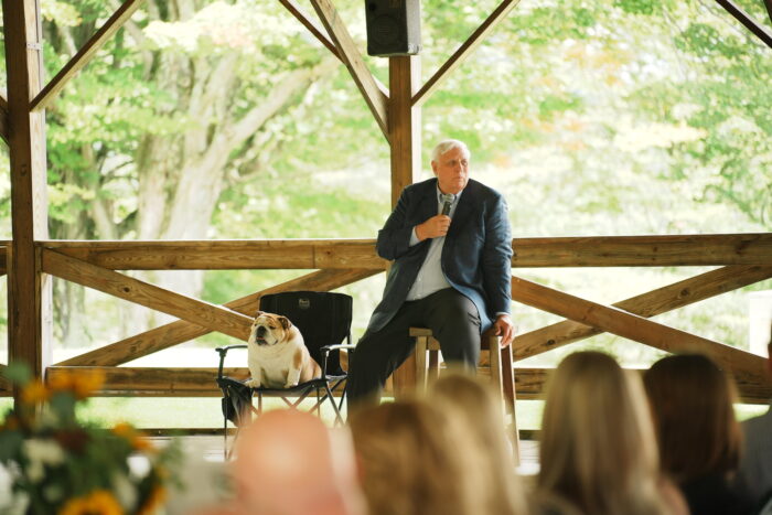 Man sits on a stool in front of a crowd