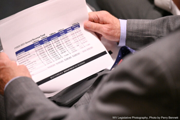 A man's hands holding a spread sheet