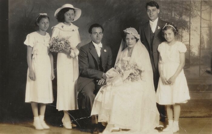 A older black and white photograph of a family on a wedding day.