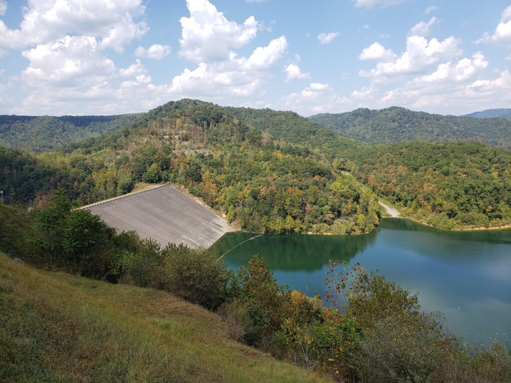 A concrete dam with lake water to one side.