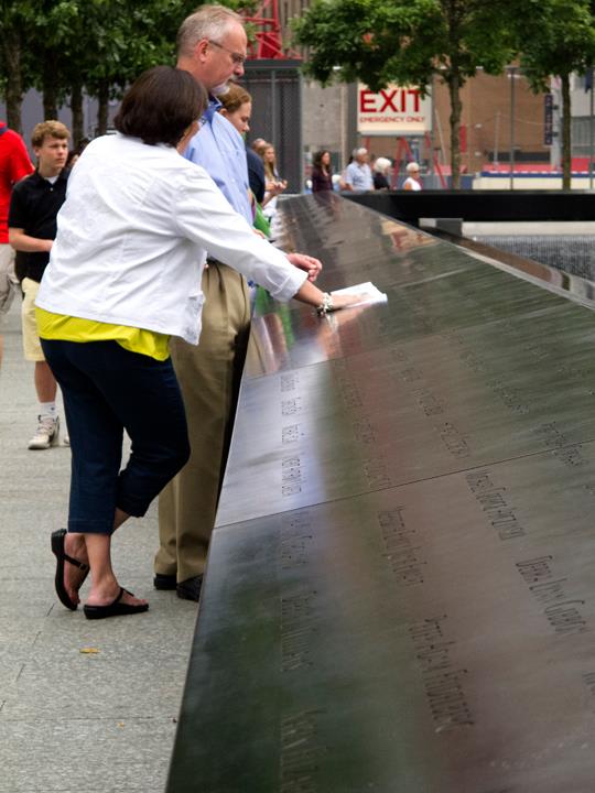 People stand looking at a memorial