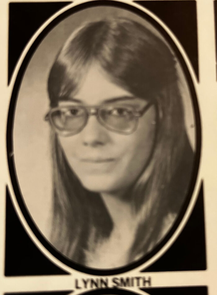 A black and white senior yearbook photo of a girl wearing glasses.