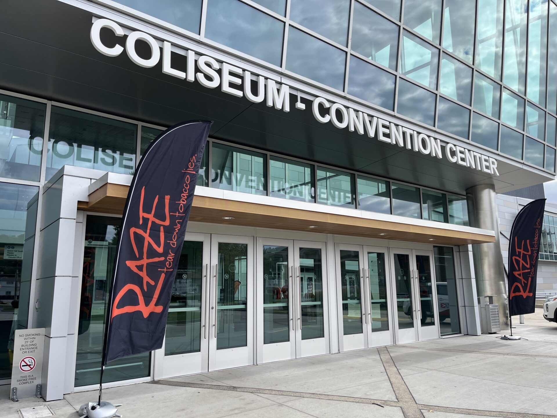 The Charleston Coliseum and Convention Center's front doors are adorned with RAZE signage: orange text with black background.