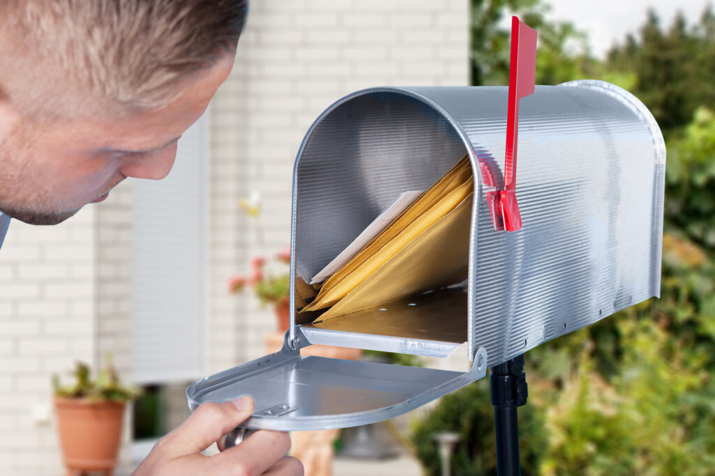 Man looks into mailbox containing envelopes