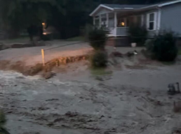A blurry image of flooding in front of a home. 