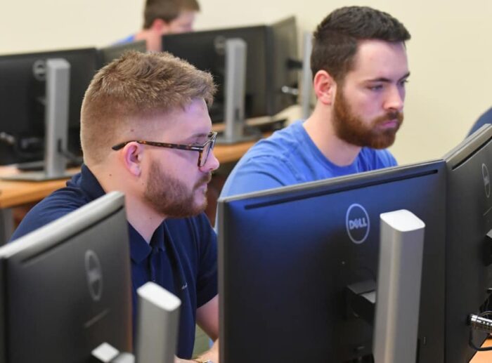 Two men look at computer screens